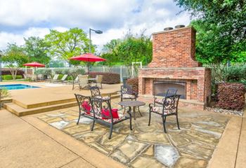 Poolside patio with outdoor fireplace and dining tables
